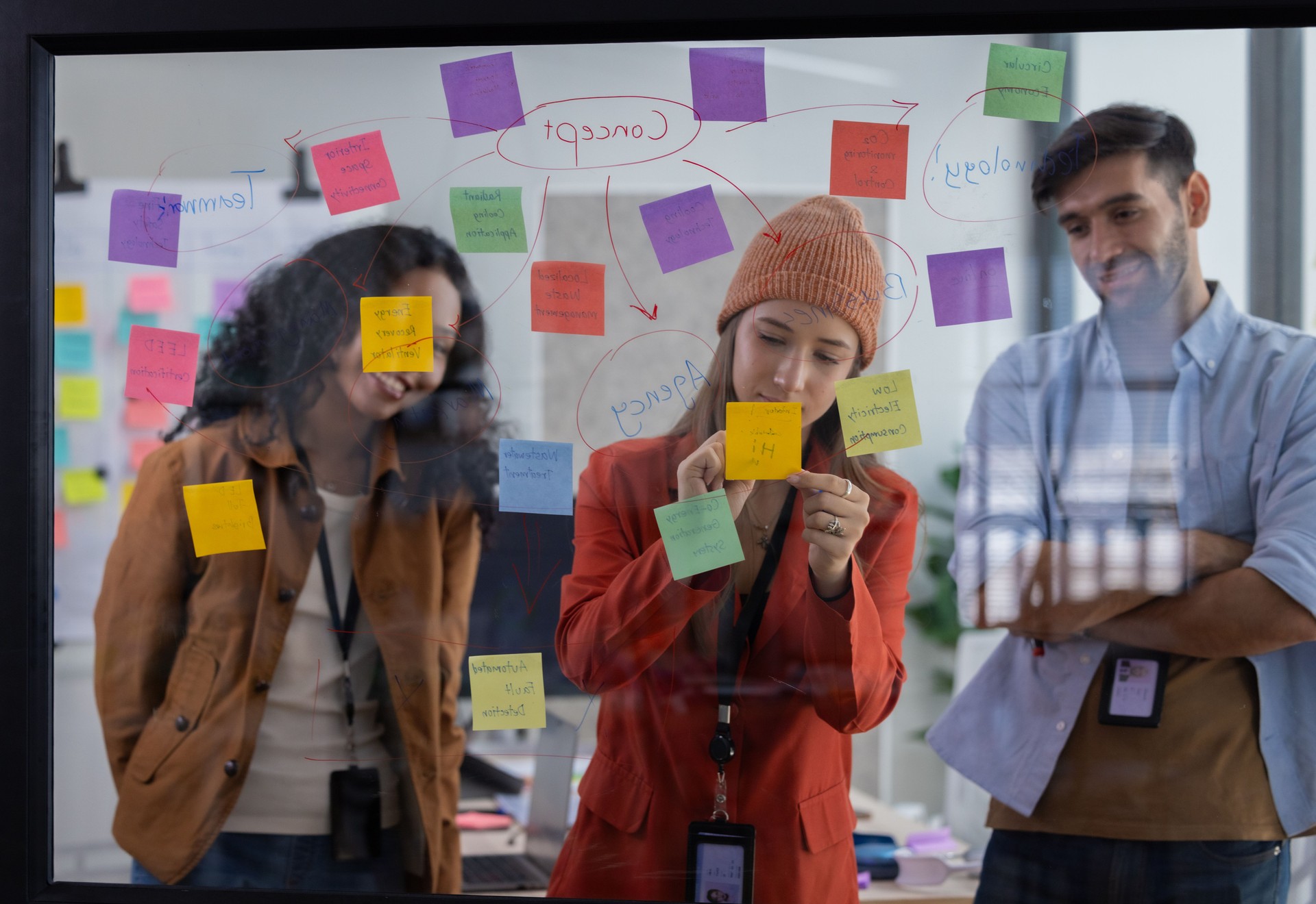 Multicultural startup team collaborate, brainstorm, exchange ideas using sticky notes for solutions
