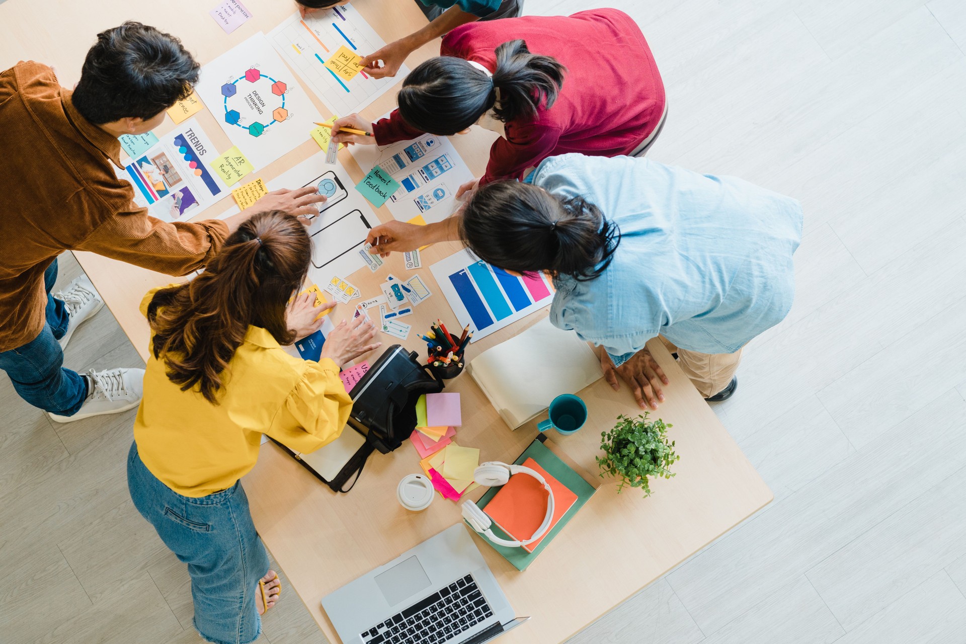 Multiracial group of young creative people in smart casual wear discussing business brainstorming meeting ideas mobile application software design project in modern office.